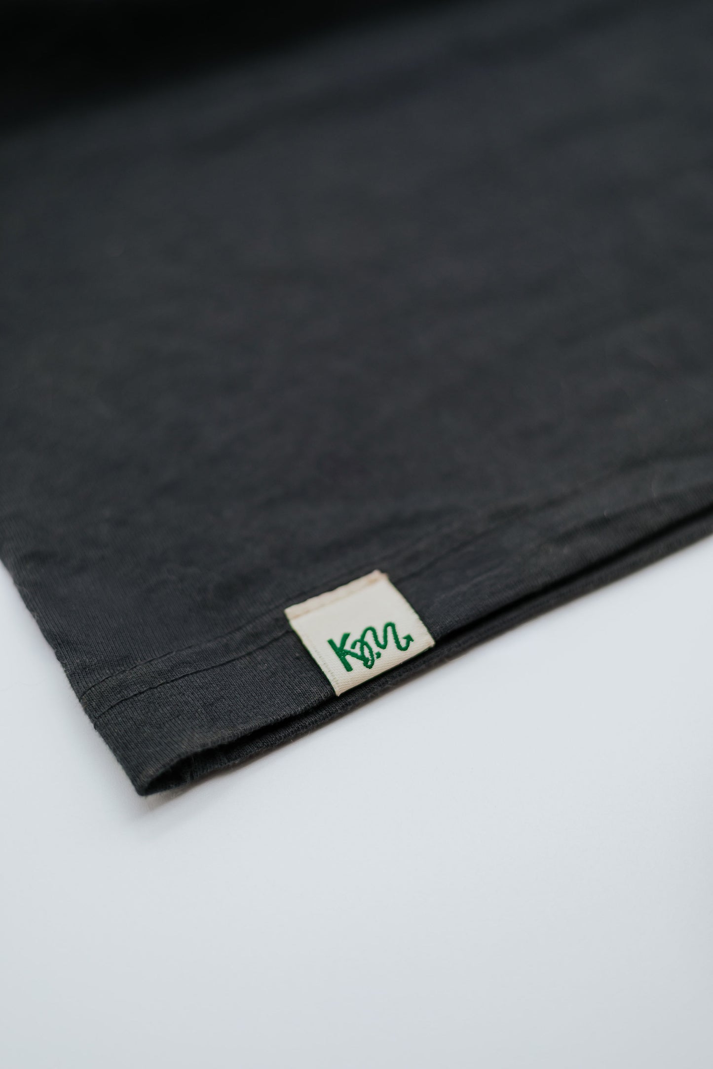 Black fabric with a brand label on a white background