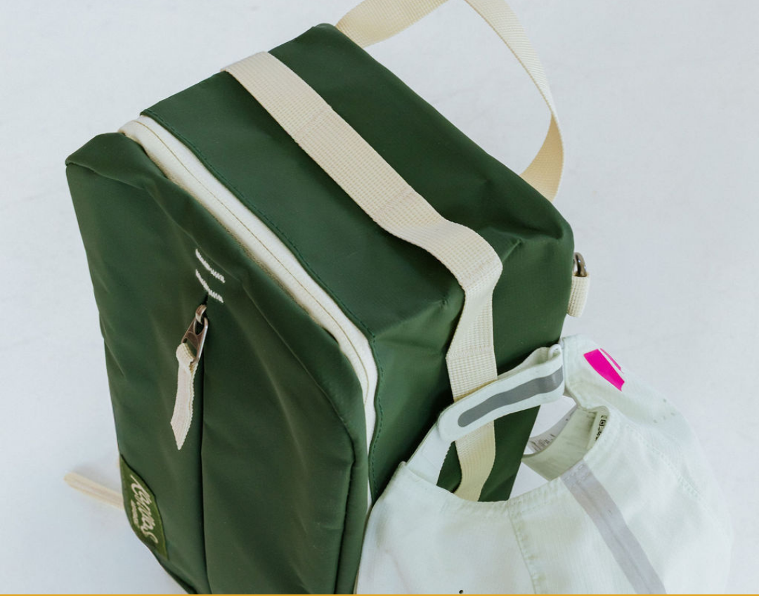 A green and cream bag with cream zipper accents 