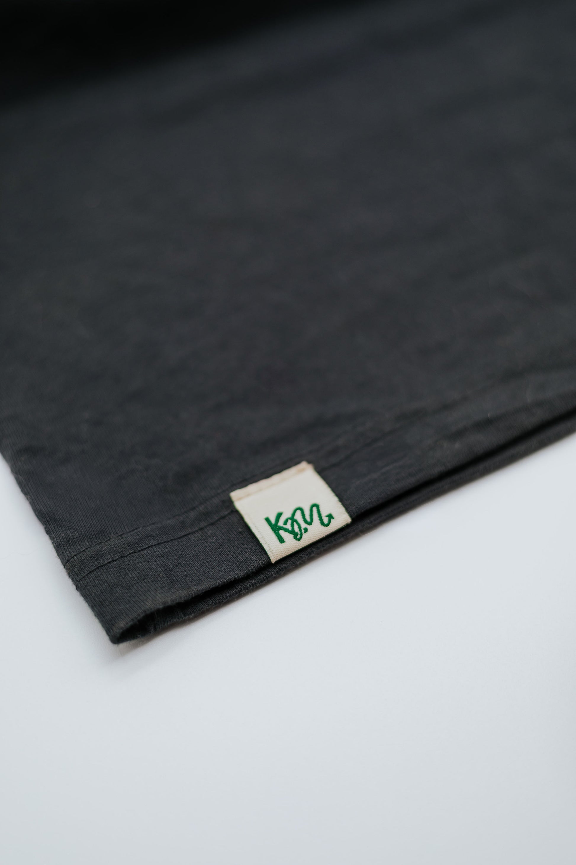 Black fabric with a brand label on a white background