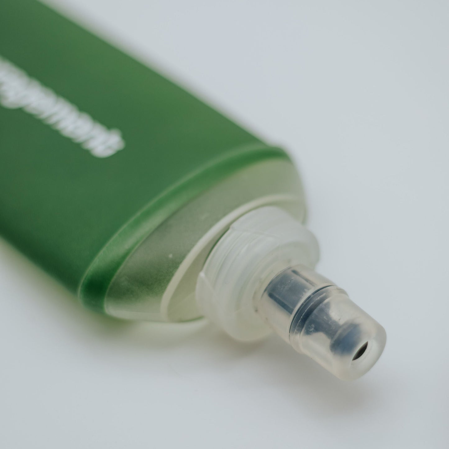 Green soft flask with a nozzle on a white background