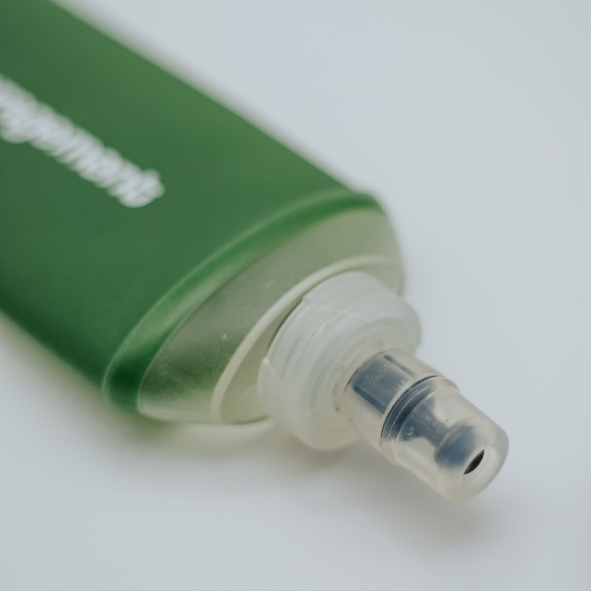 Green soft flask with a nozzle on a white background