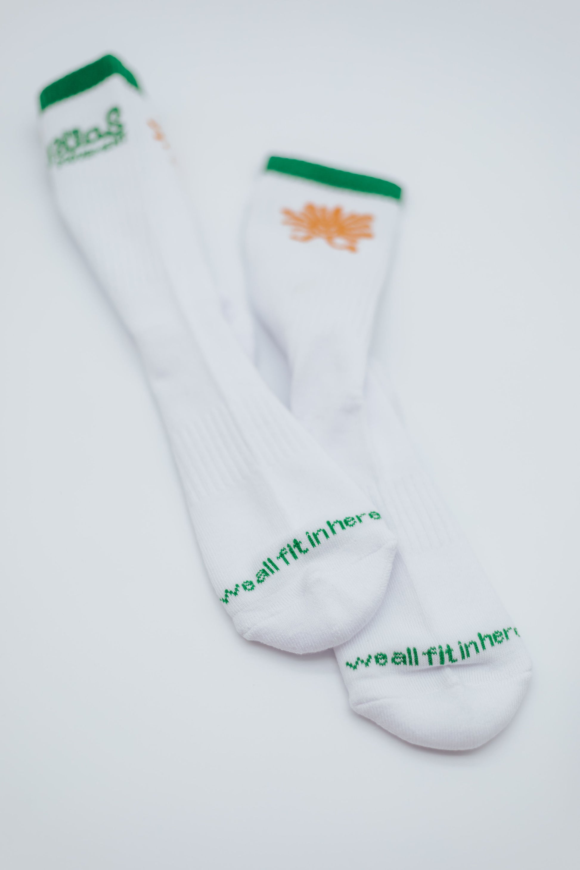 White socks with green and orange text on a white background