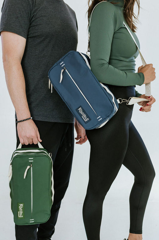 Two people holding green and blue bags against a white background