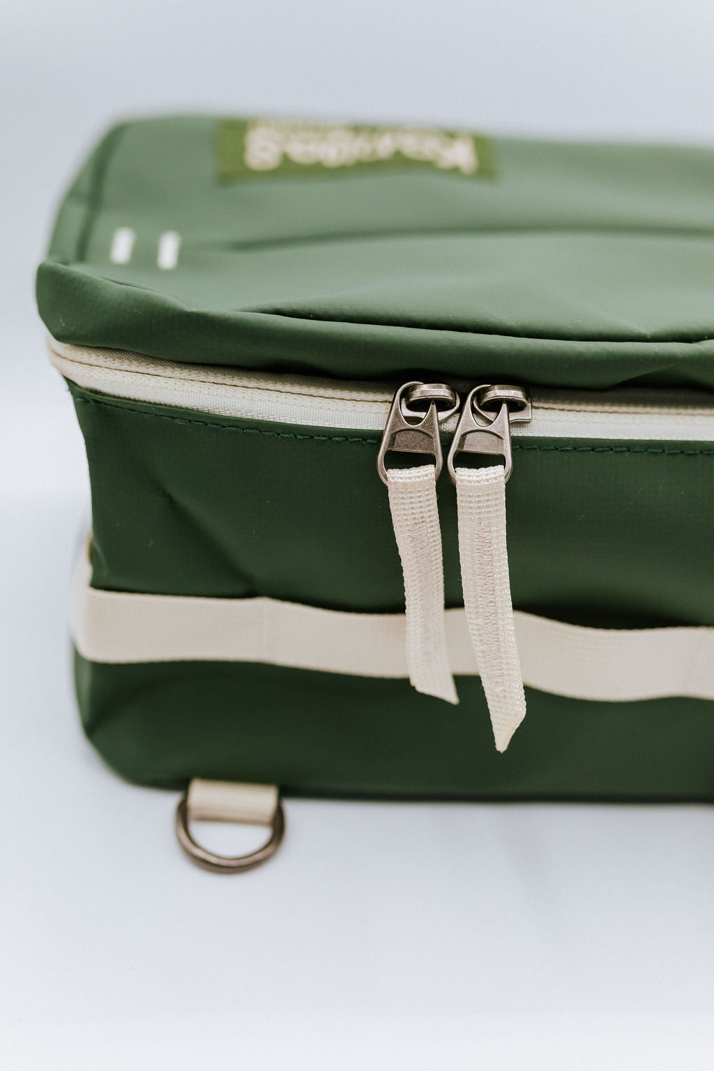 Green bag with cream zipper on a white background
