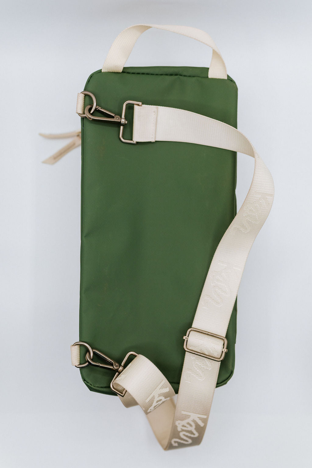Green bag  with beige straps on a light gray background