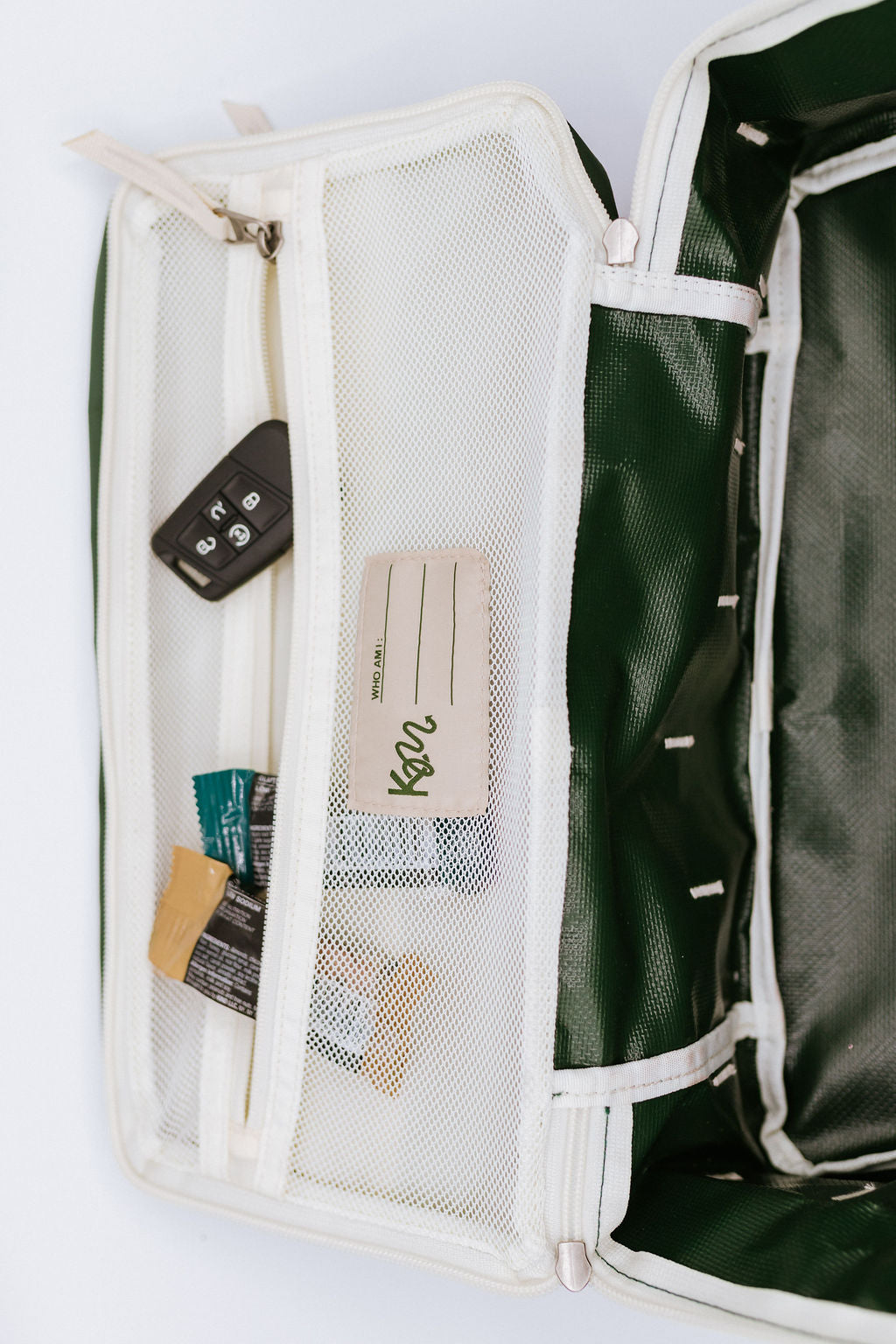 Green show bag with mesh pocket on a white background
