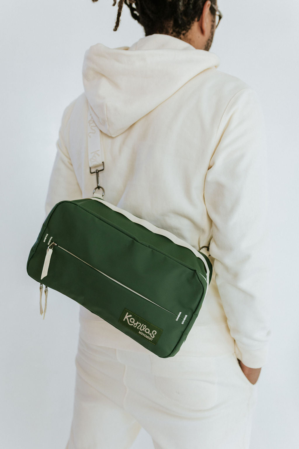 Person wearing a green bag with 'Kanvas Movement' branding on a white background